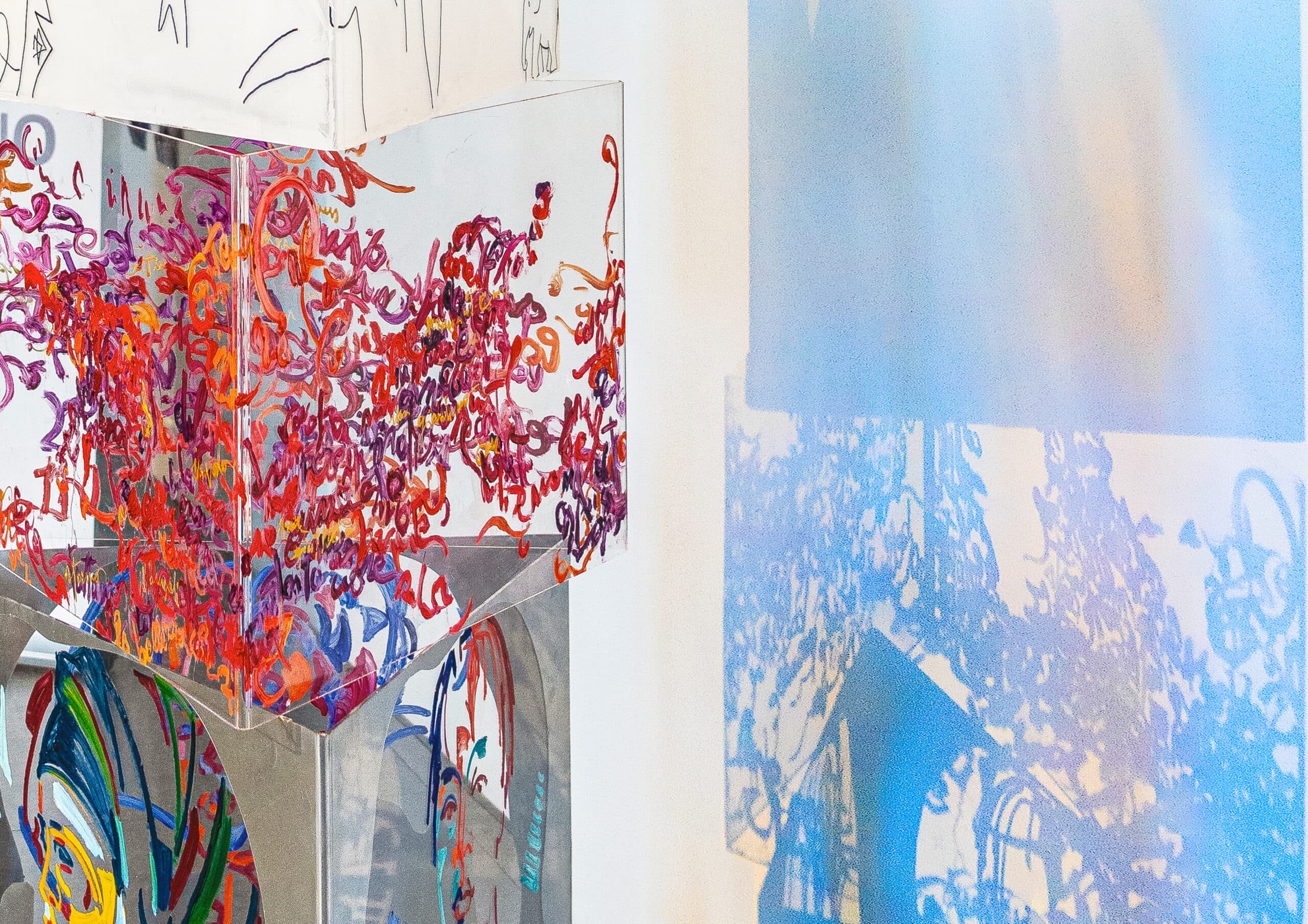 Art installation featuring colorful abstract patterns and reflections on a transparent structure.